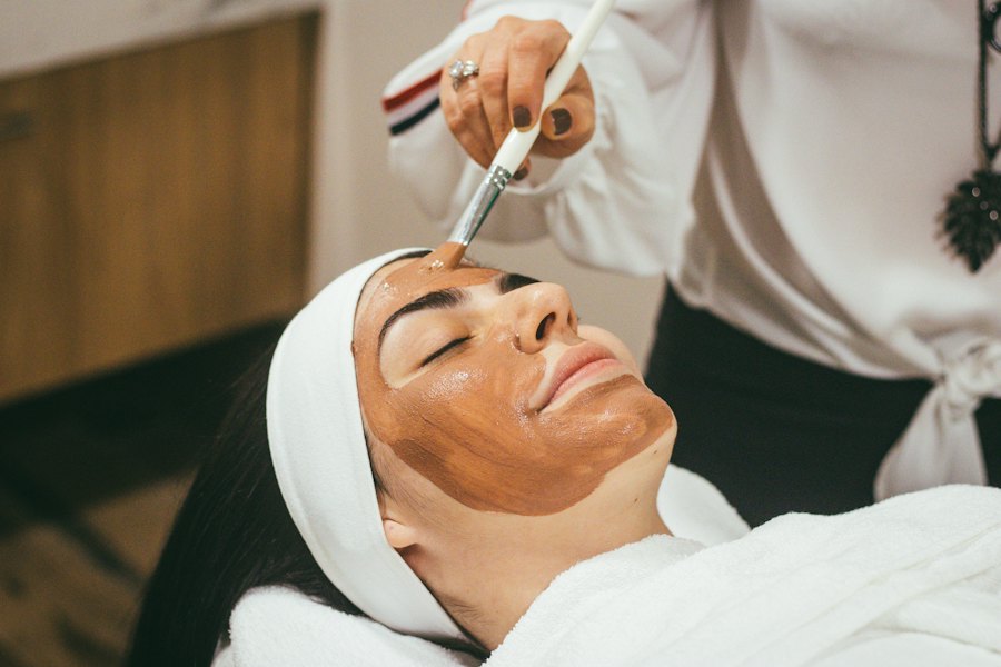 Una profesional aplica una mascarilla facial a una clienta